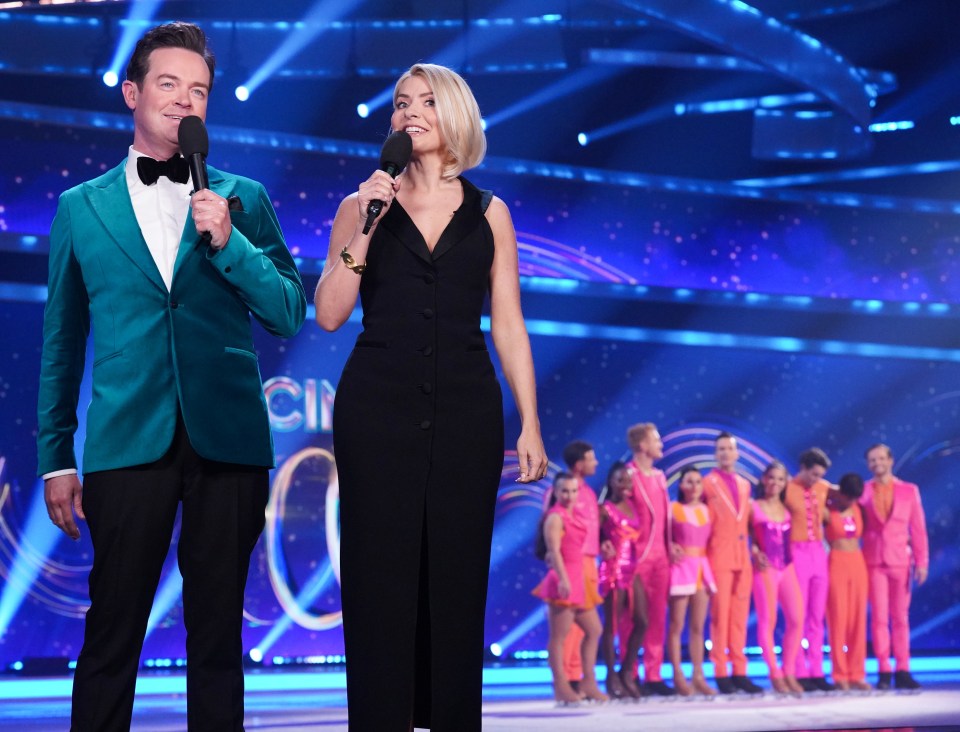 a man and a woman stand on a stage holding microphones