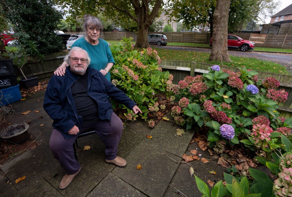 a man sits in a chair while a woman stands behind him