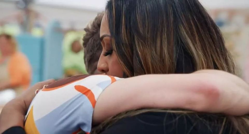 two women are hugging each other in a room .