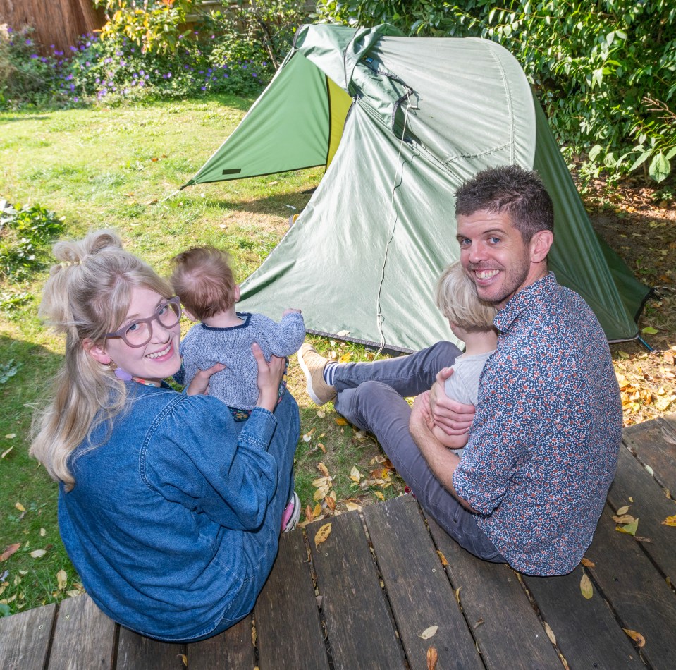 a family sits on a deck in front of a tent