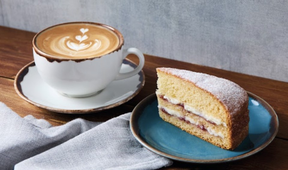 a slice of cake next to a cup of coffee