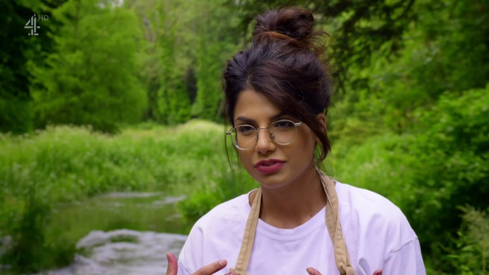 a woman wearing glasses and an apron is standing in front of a river with 4hd written on the bottom of the screen