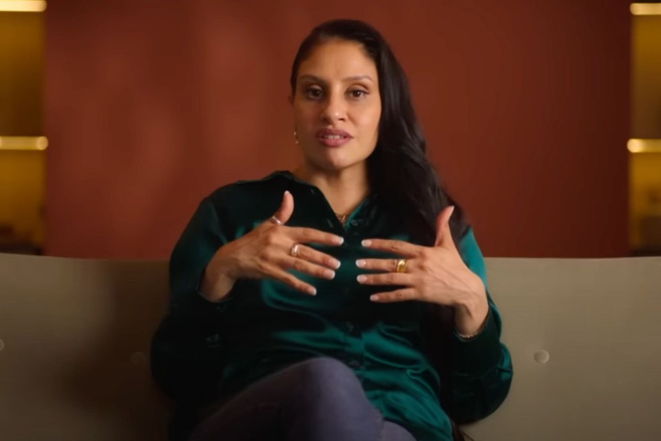 a woman sitting on a couch with her hands on her chest