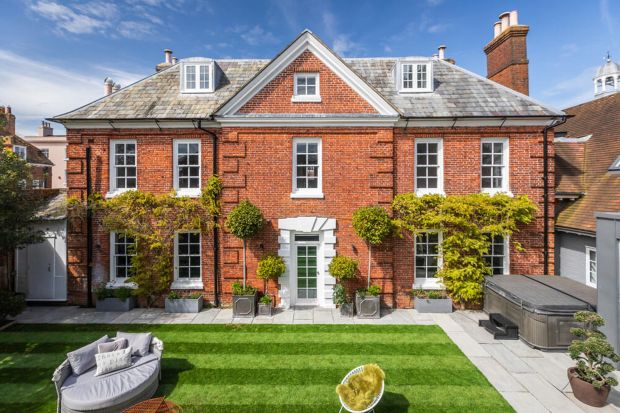 a large red brick house with a hot tub in the backyard