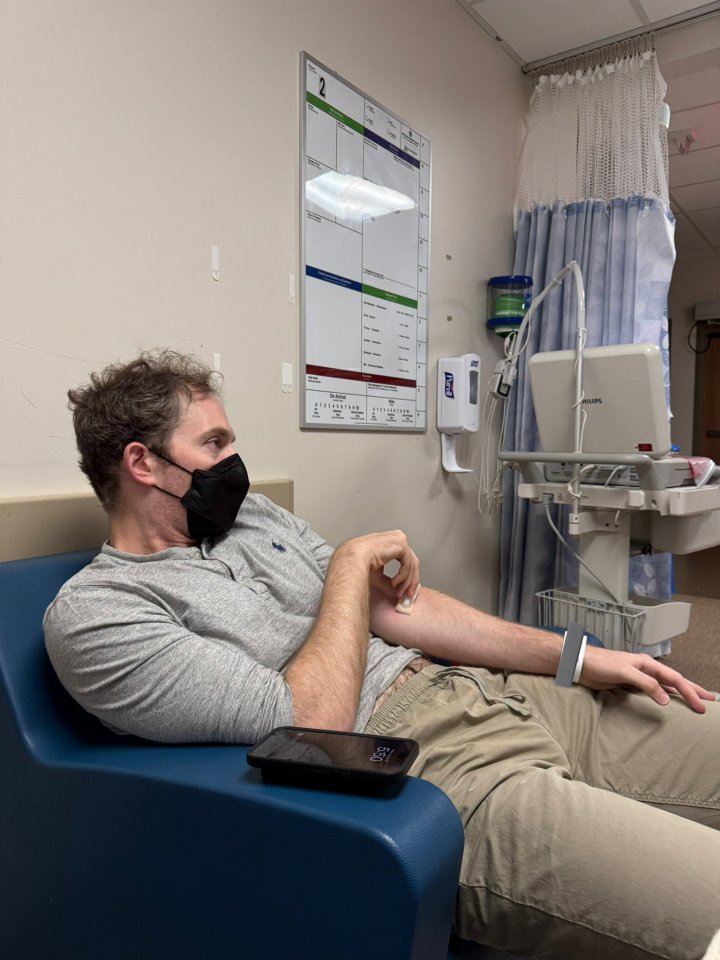 a man wearing a mask is laying in a hospital chair