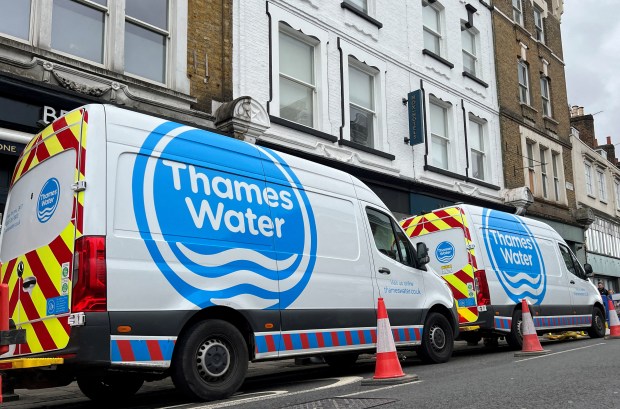 three thames water vans are parked in front of a building