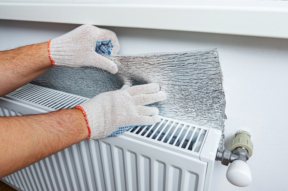 a person wearing gloves is working on a radiator