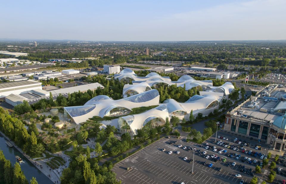 an aerial view of a city with a large white building in the middle