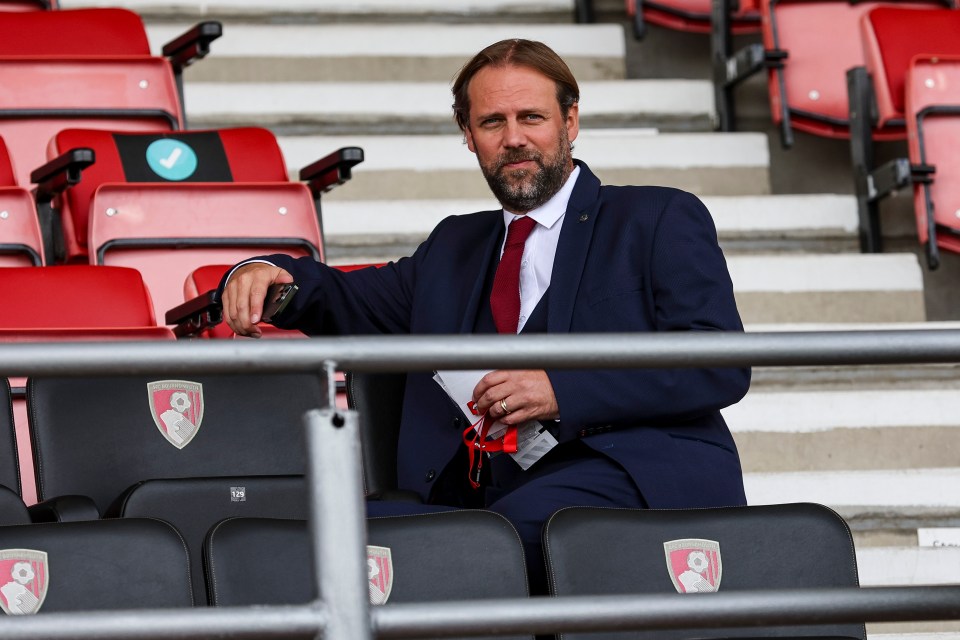 a man in a suit sits in an empty stadium