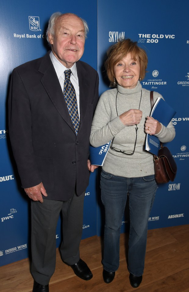 a man and woman standing in front of a blue wall that says skylon