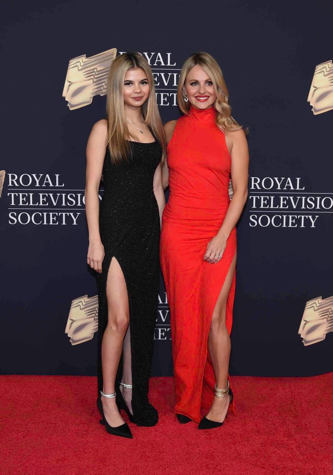 two women stand on a red carpet that says royal television society