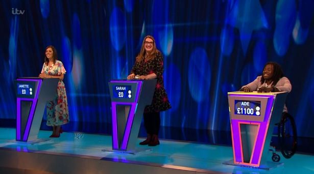 three women are sitting at purple podiums on a stage .