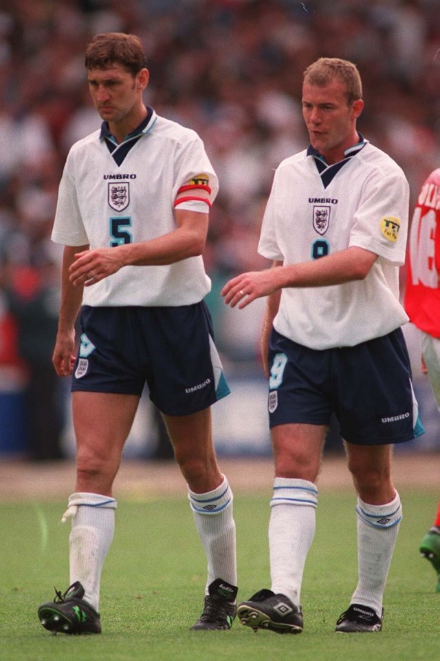 two soccer players wearing umbro jerseys stand on the field