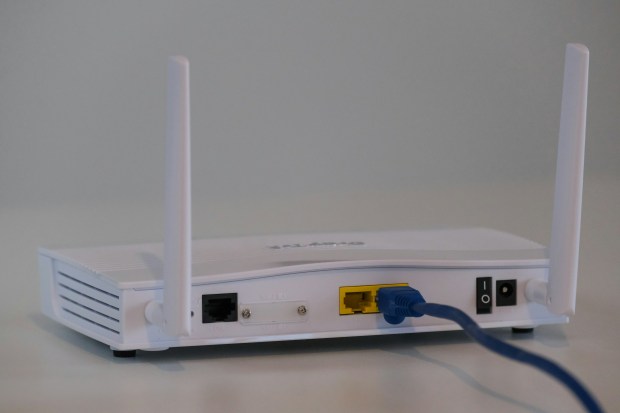 a white router with a blue cable plugged into it