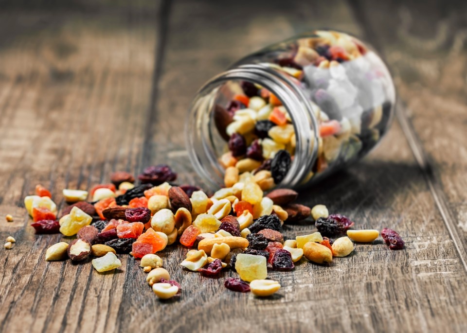 a jar of dried fruits and nuts on a wooden table