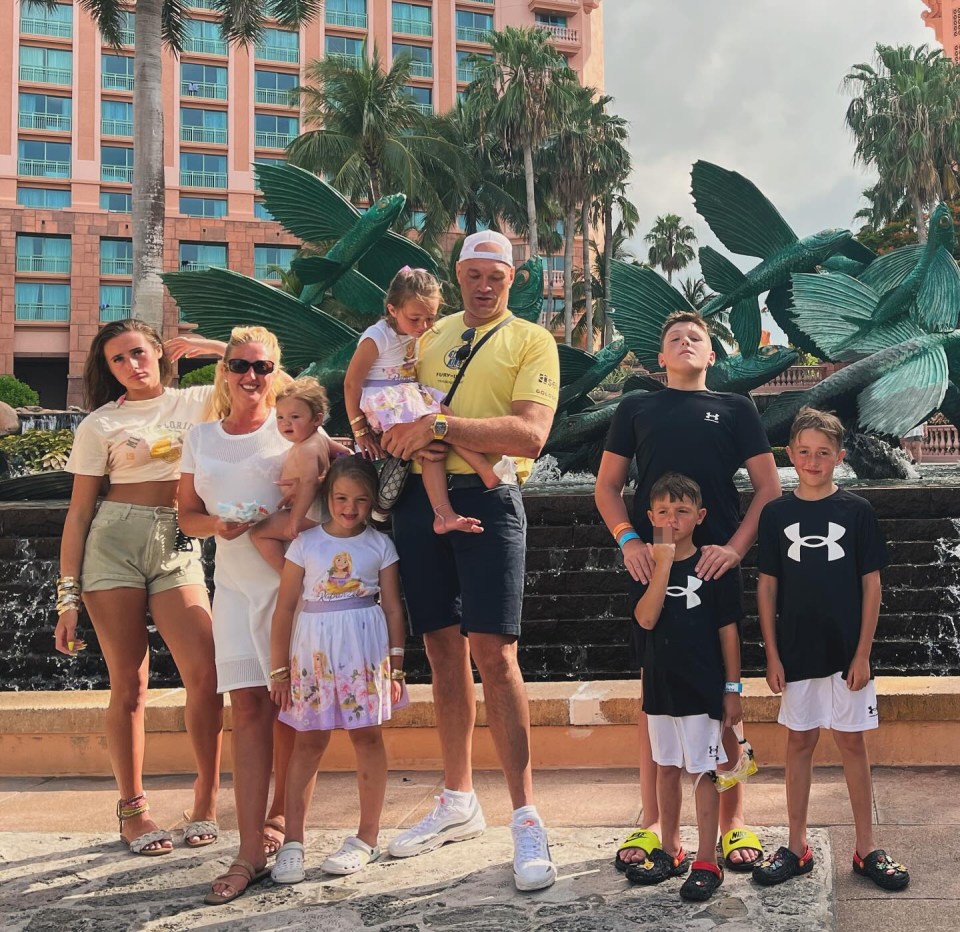 a family standing in front of a fountain wearing under armour shirts