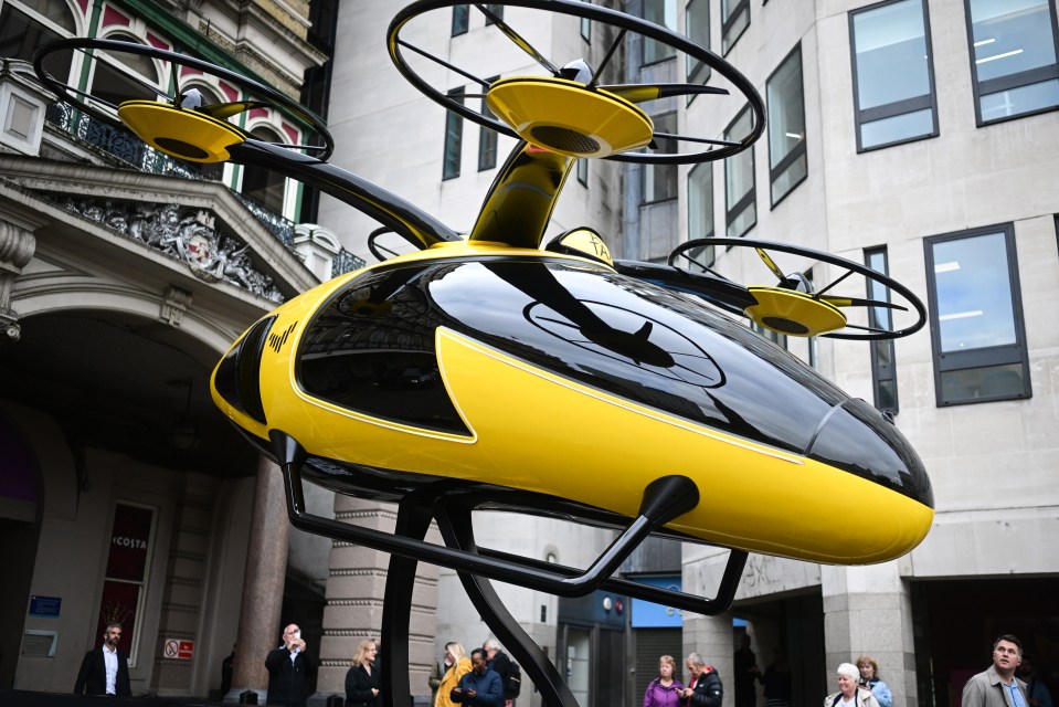 a yellow and black helicopter is in front of a costa coffee store