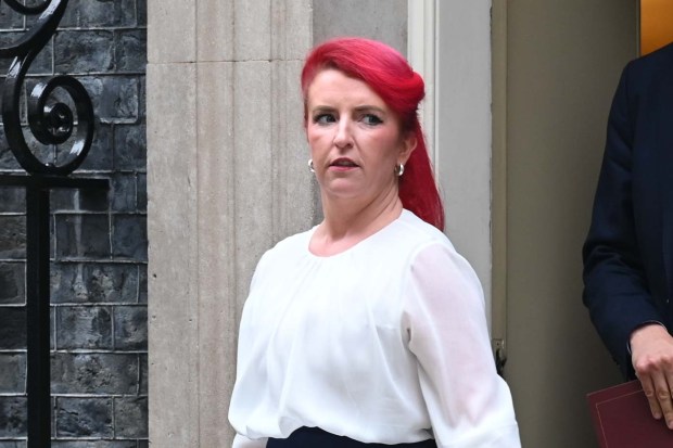 a woman with red hair is standing in front of a building