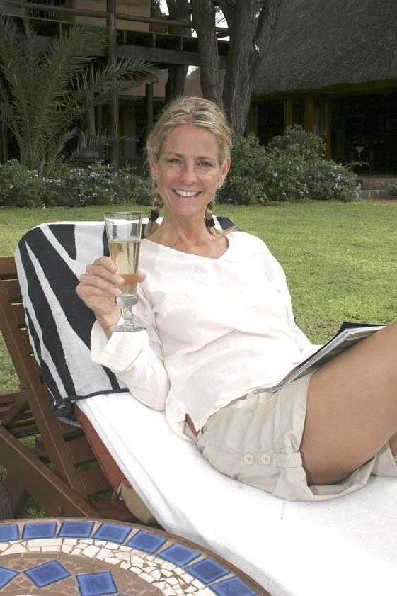 a woman sits in a chair holding a glass of wine