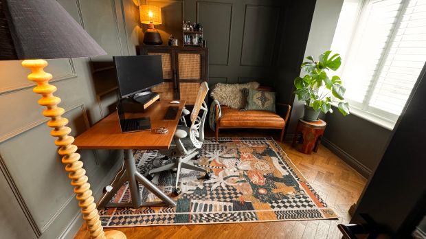 a room with a rug and a desk with a computer on it