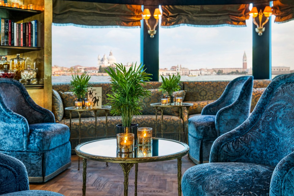 a room with blue chairs and a table with candles on it