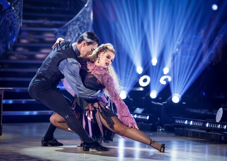 two dancers on a stage with a purple background