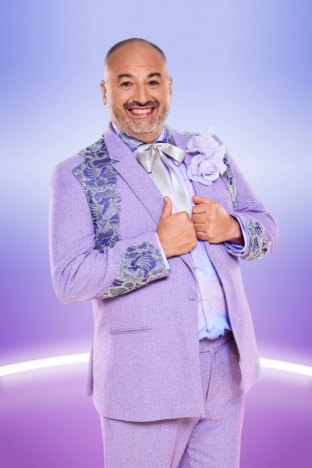 a man in a purple suit and tie is smiling