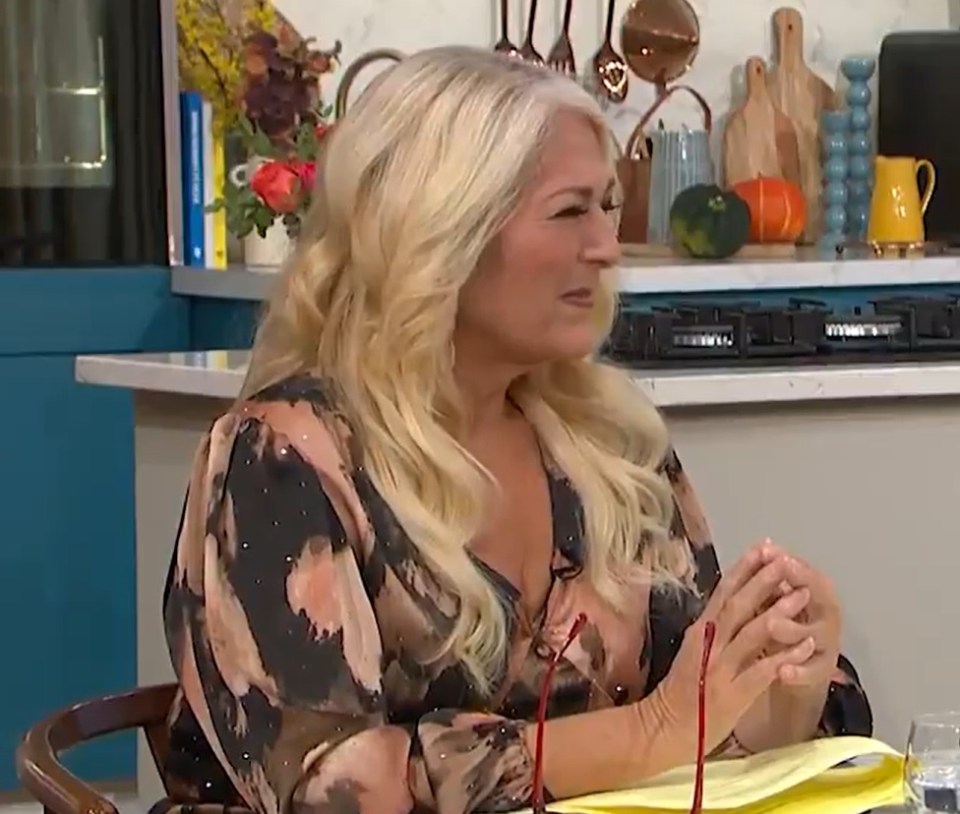 a woman is sitting at a table with her hands folded