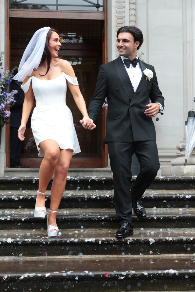 a bride and groom are walking down the steps of a building