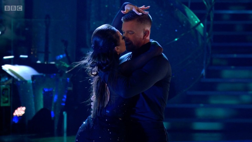 a man and a woman are dancing in front of a bbc logo