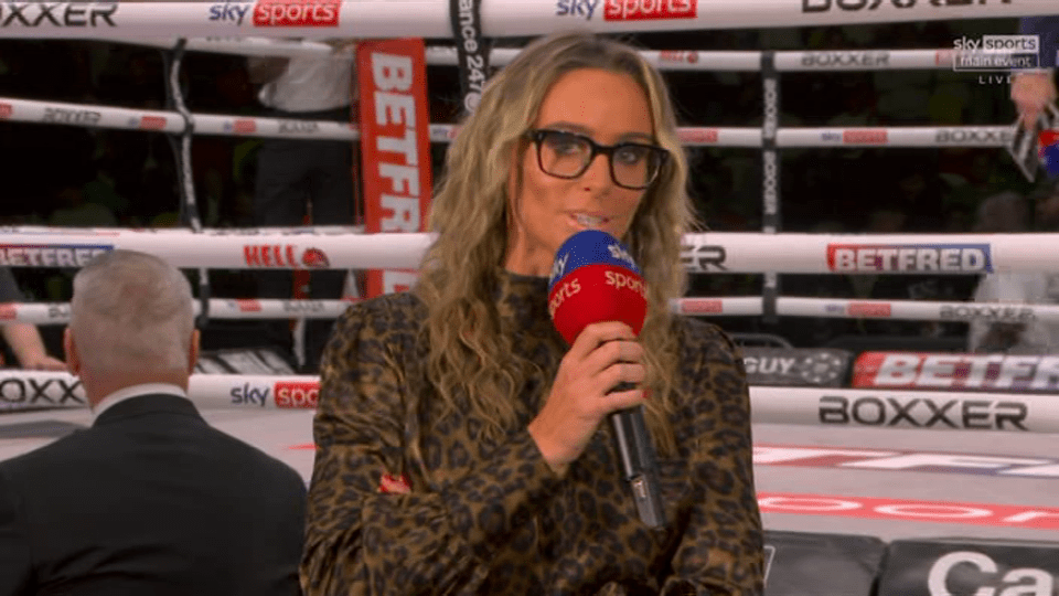 a woman holding a microphone in front of a boxing ring that says sky sports