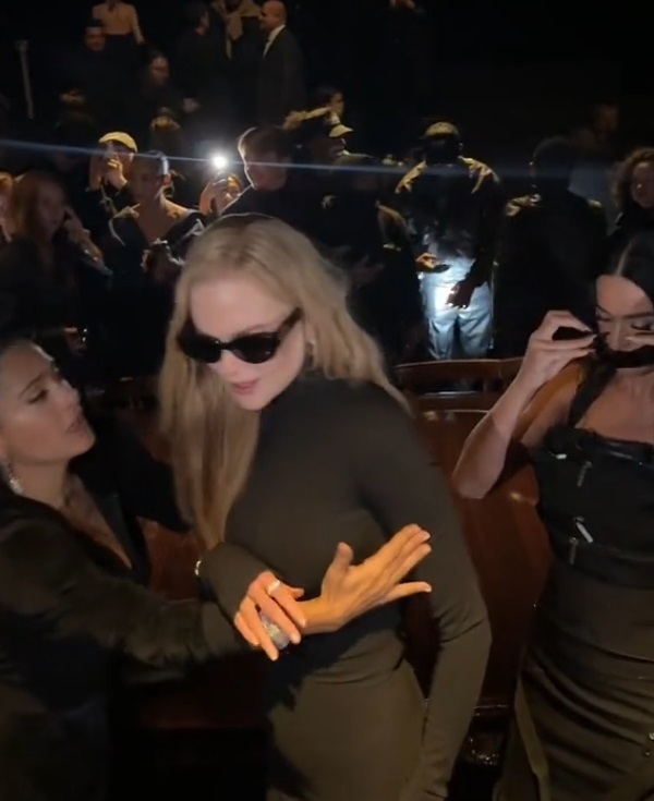 a woman wearing sunglasses is standing next to another woman