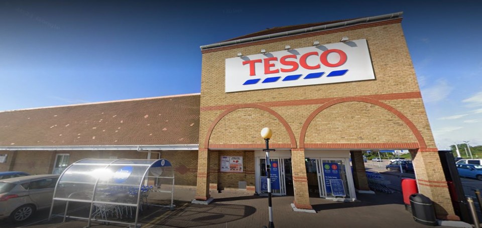 the outside of a tesco store with cars parked in front of it