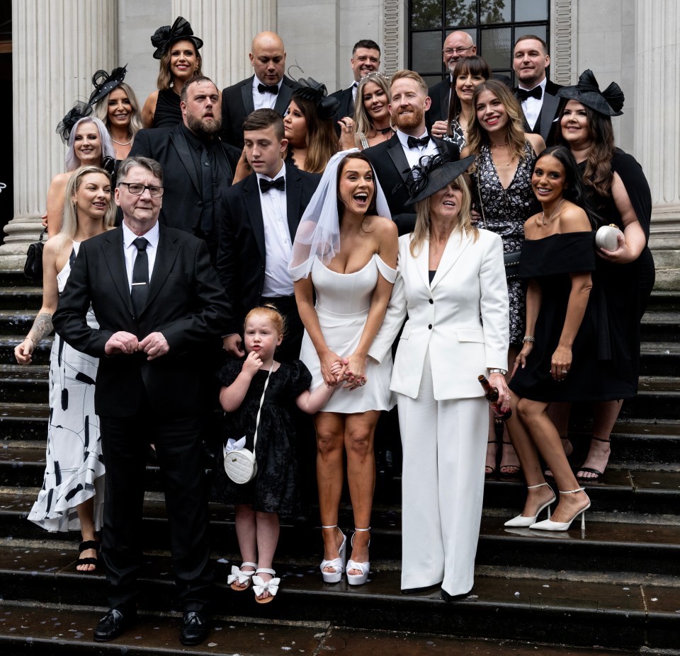 a group of people posing for a picture on the steps of a building