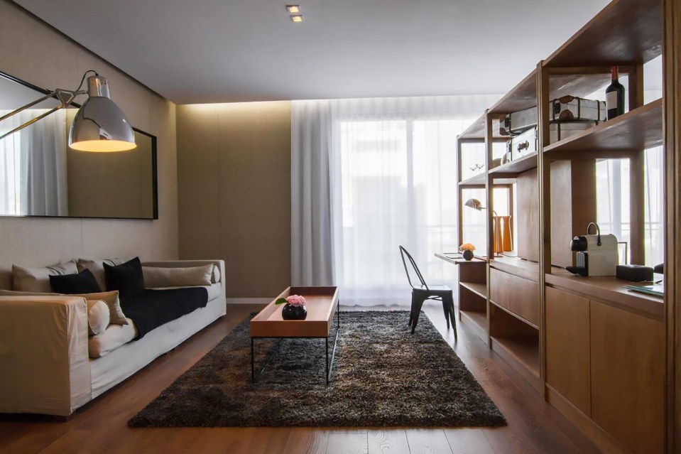 a living room with a white couch and a black rug