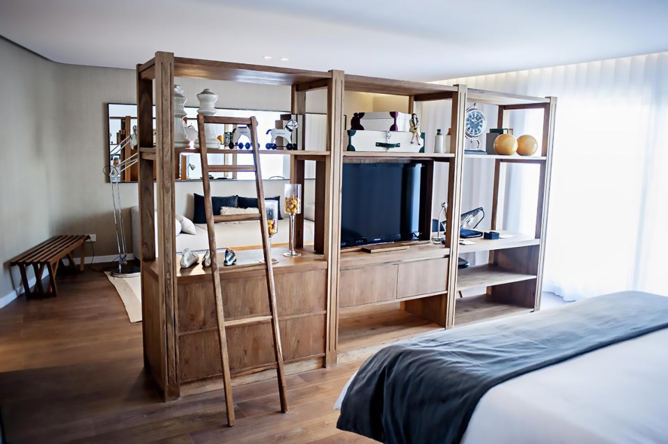 a bedroom with a ladder leading up to a tv