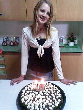 a woman is standing in front of a cake with candles on it .