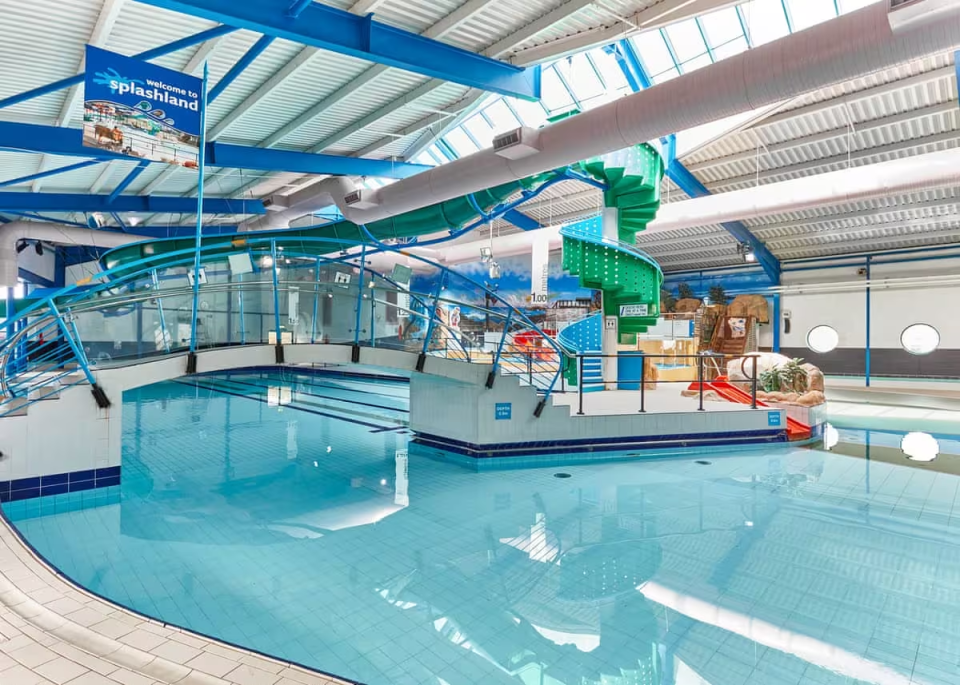 an indoor swimming pool with a sign that says welcome to splashland