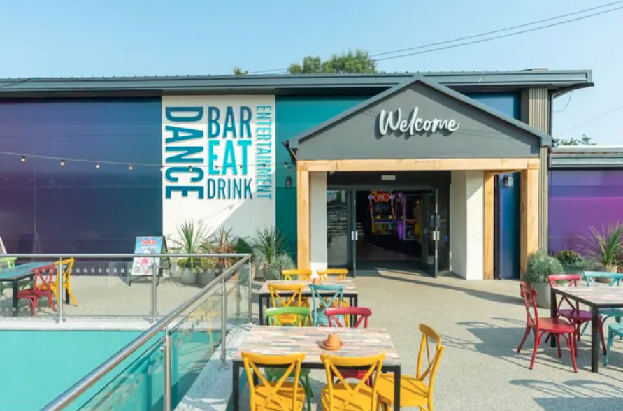 a restaurant with tables and chairs and a welcome sign