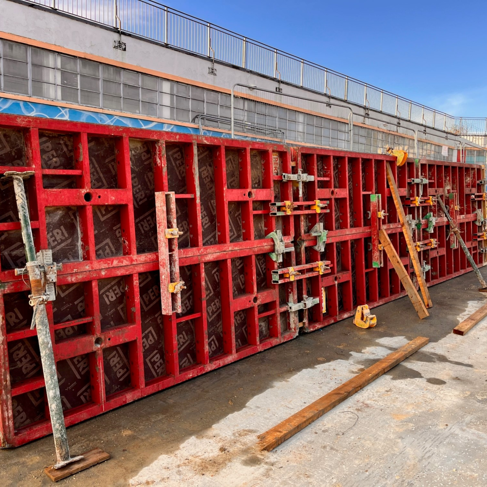 The red wall in place is a temporary fixture to allow the wet concrete to harden and set