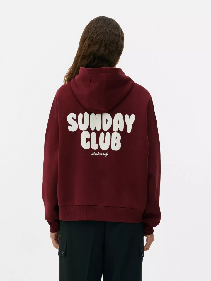 a woman wearing a maroon sunday club hoodie