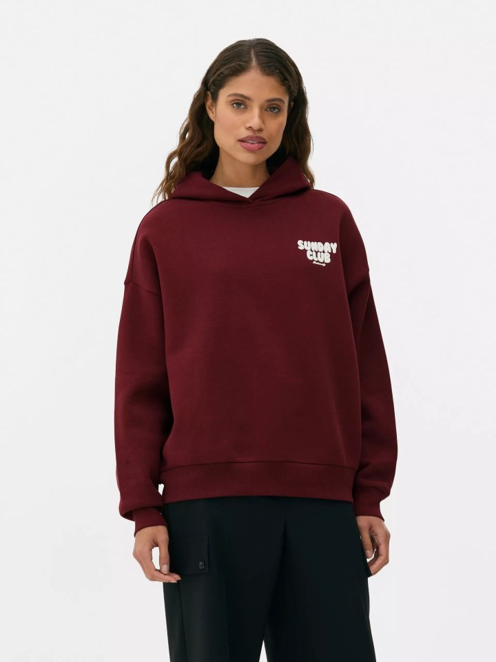 a woman wearing a maroon hoodie that says sunday club