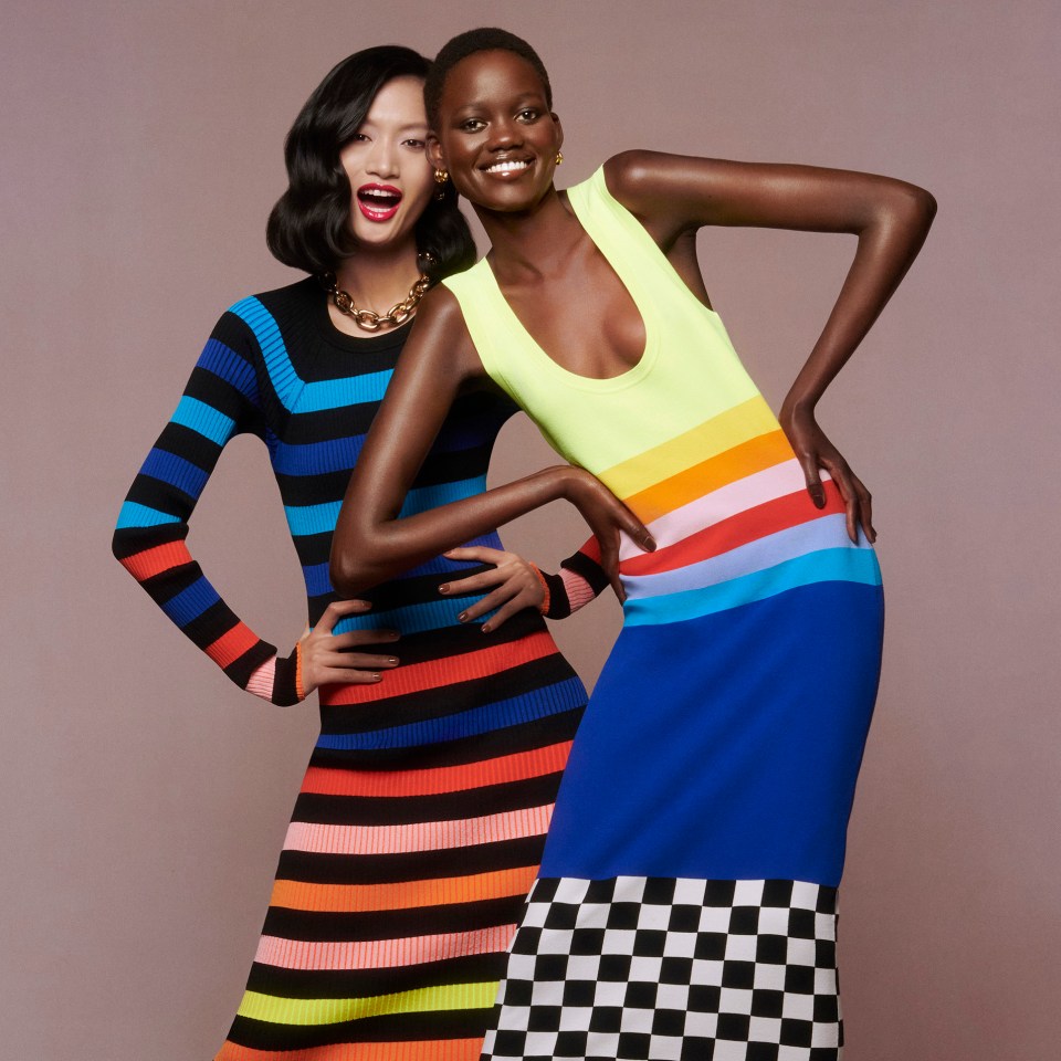 two women wearing colorful striped dresses pose for a photo