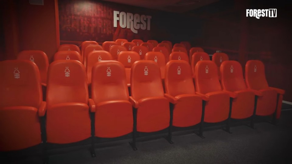 The video room has rows of comfy red seats