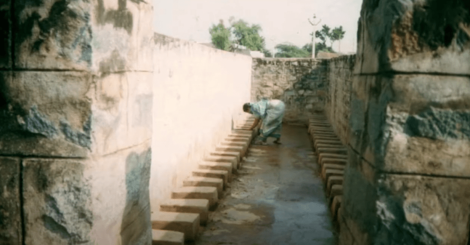 a woman is kneeling down in a row of bricks