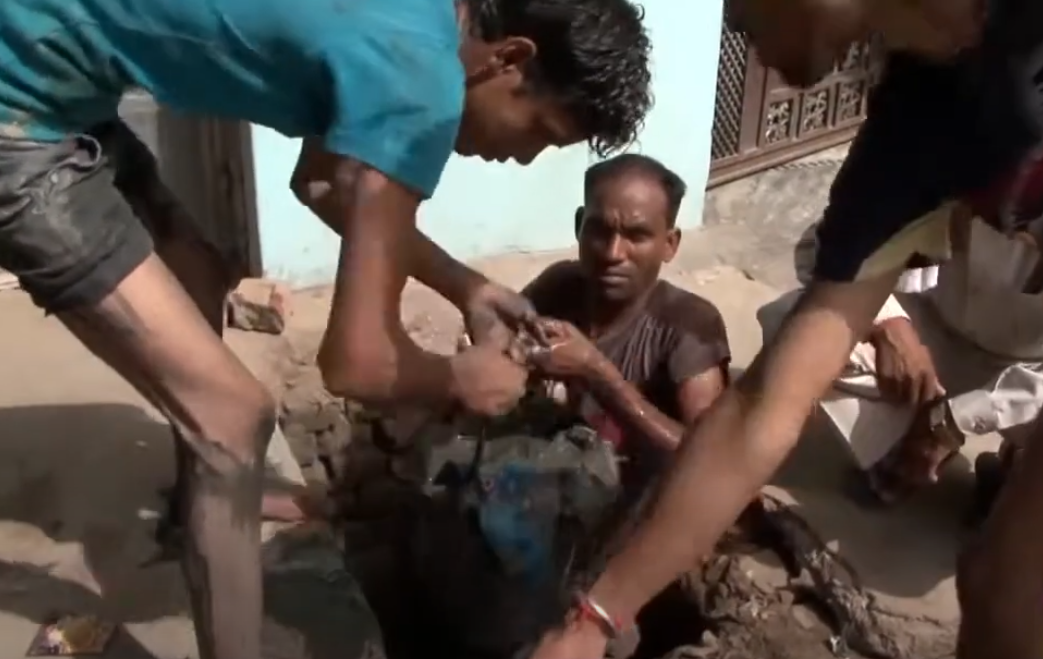 a group of men are working on a man 's leg