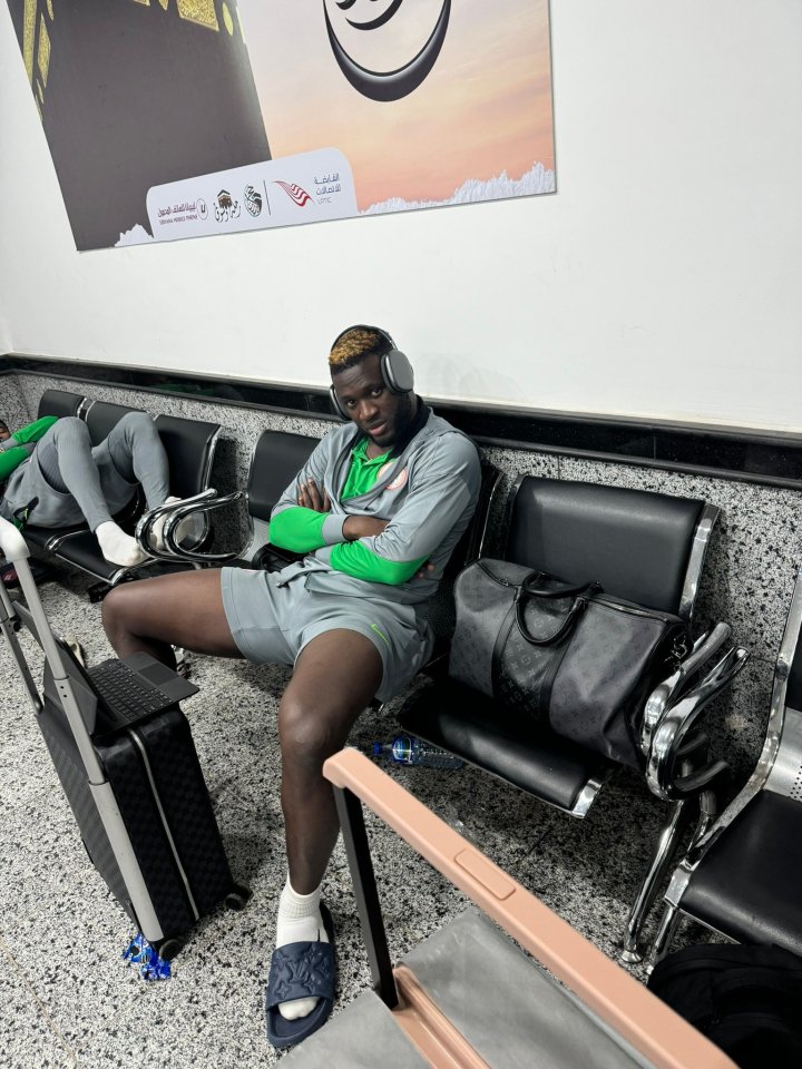 a man wearing headphones sits in a waiting room