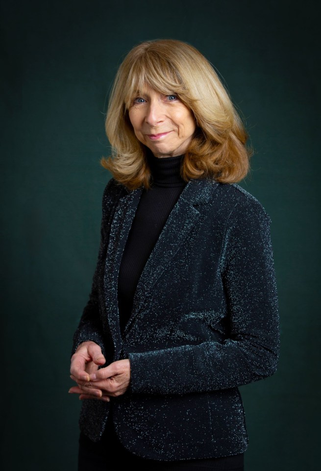 a woman with blonde hair is wearing a black turtleneck and a black jacket