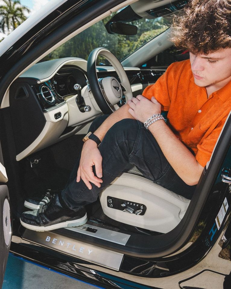 a man sits in the driver 's seat of a bentley car