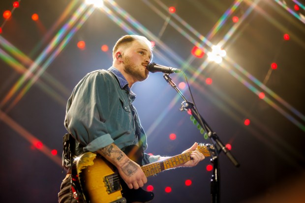 a man singing into a microphone while playing a guitar